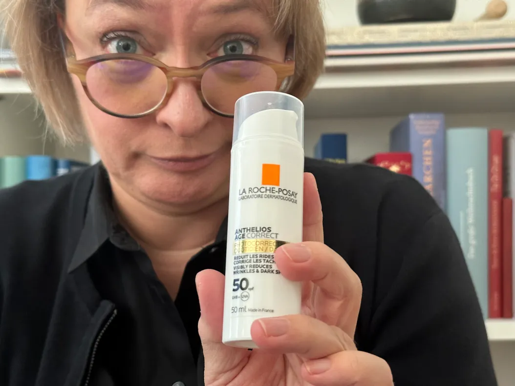 Ich mit kritischem Blick und einer Creme, die das Alter korrigieren soll
